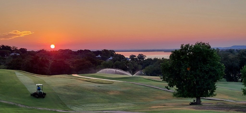 Golf course at sunset with tree on fairway